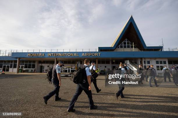 In this handout provided by the Australian Department of Defence, Officers from the Australian Federal Police arrive at Honiara International Airport...