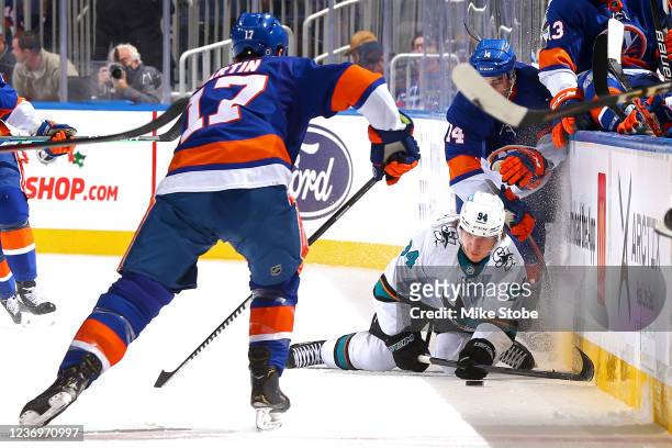 Alexander Barabanov of the San Jose Sharks battles for the puck with Andy Andreoff and Matt Martin of the New York Islanders during the first period...