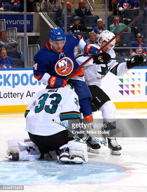 Andy Andreoff of the New York Islanders collides with Adin Hill of the San Jose Sharks during the third period at UBS Arena on December 02, 2021 in...