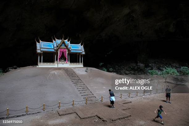 This photo taken on December 2, 2021 shows visitors next to the 19th century pavilion inside Phraya Nakhon Cave at Khao Sam Roi Yot National Park in...