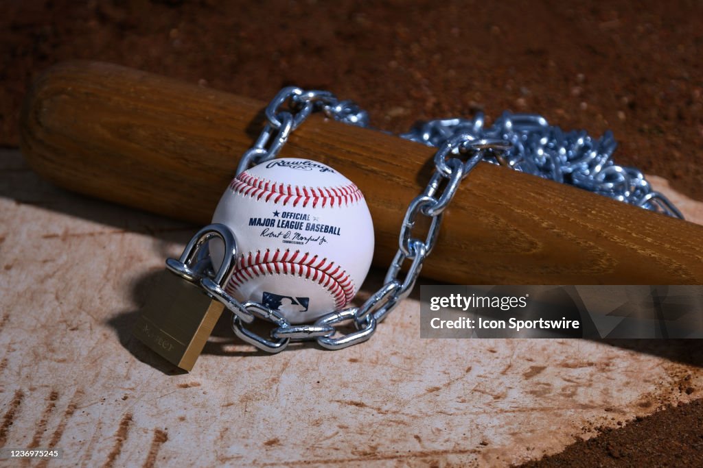 An Official Rawlings Major League Baseball sits with a bat, lock and ...