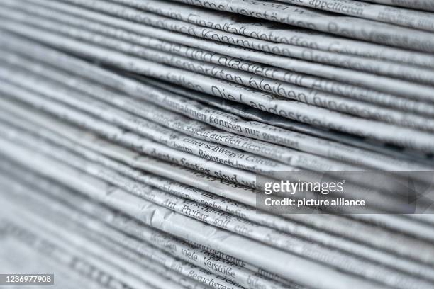 December 2021, Saxony, Dresden: ILLUSTRATION - A stack of various daily newspapers lies on a table. Photo: Sebastian Kahnert/dpa-Zentralbild/ZB