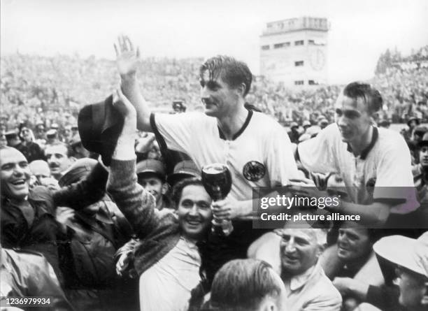 July 1954, Switzerland, Bern: German striker and captain Fritz Walter and his Lauter teammate Horst Eckel are carried off the pitch by enthusiastic...