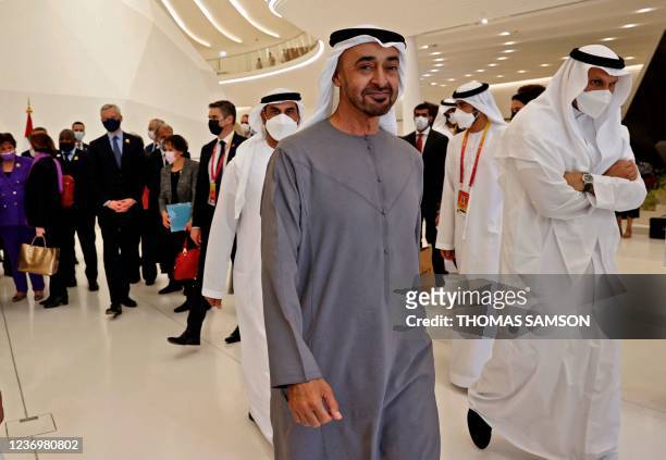 French President Emmanuel Macron is greeted by Abu Dhabi's Crown Prince Mohammed bin Zayed al-Nahyan during his tour of the Emirates pavillion at the...