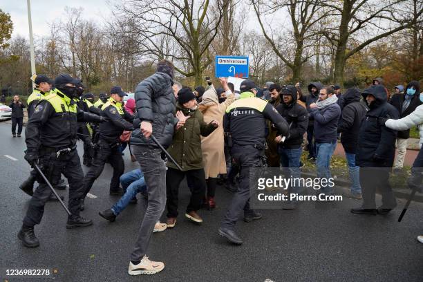 Dutch police officers push back a group of Kurdish protesters outside the building housing the Organisation for the Prohibition of Chemical Weapons...