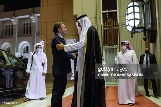 Qatar's Emir Sheikh Tamim bin Hamad Al-Thani receives French President Emmanuel Macron at the Amiri Diwan in the capital Doha on December 3, 2021.