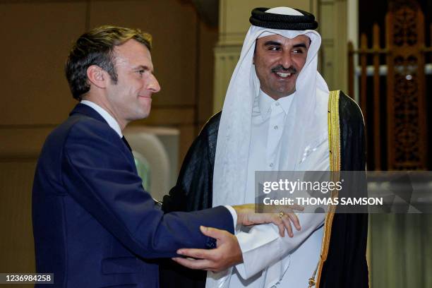 Qatar's Emir Sheikh Tamim bin Hamad Al-Thani receives French President Emmanuel Macron at the Amiri Diwan in the capital Doha on December 3, 2021.