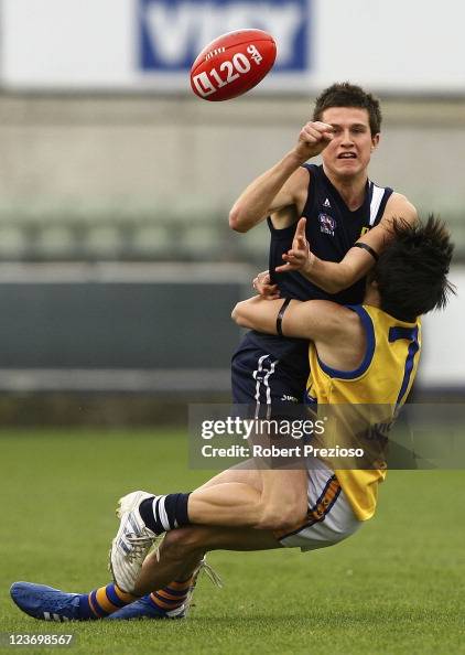 Jackson Merrett Jackson Merrett of the Falcons handballs under pressure from Jordan ...