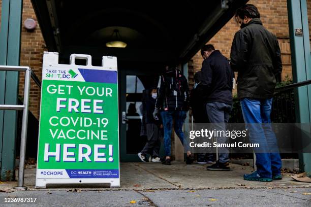 People line up outside of a free COVID-19 vaccination site that opened today in the Hubbard Place apartment building on December 3, 2021 in...