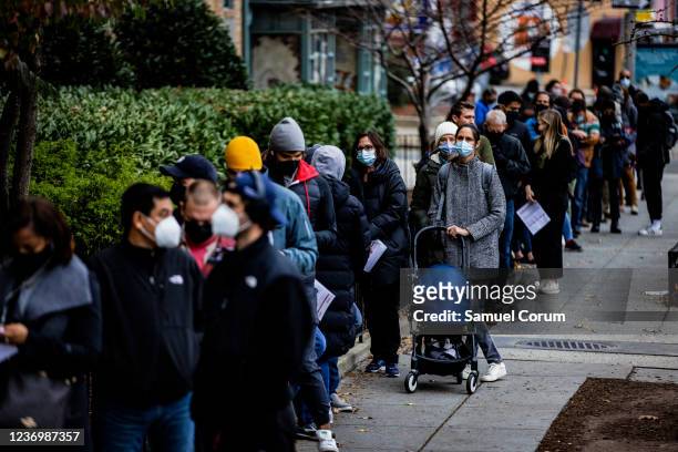 People line up outside of a free COVID-19 vaccination site that opened today in the Hubbard Place apartment building on December 3, 2021 in...