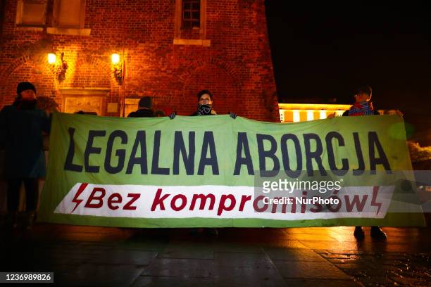 People hold a banner reading 'Legal Abortion Without Compromise' while attending 'Do not want my blood, Poland!' protest at the Main Square in...