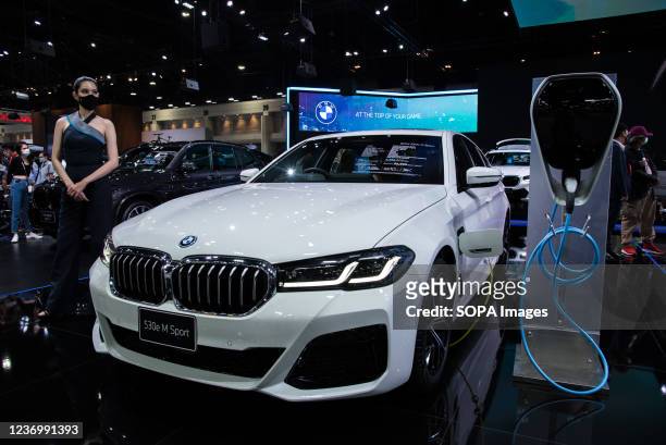 Model poses next to a "BMW 530e M Sport" car displayed at the Motor Expo. The 38th Thailand International Motor Expo 2021 held from December 1,2021...