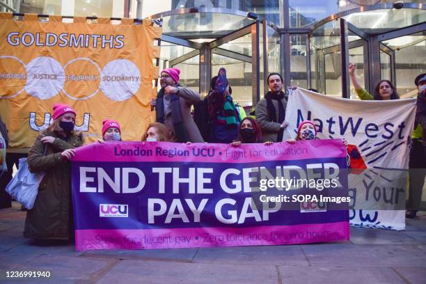 Protesters hold an 'End The Gender Pay Gap' banner during the demonstration outside the NatWest head office in Bishopsgate. University staff members...