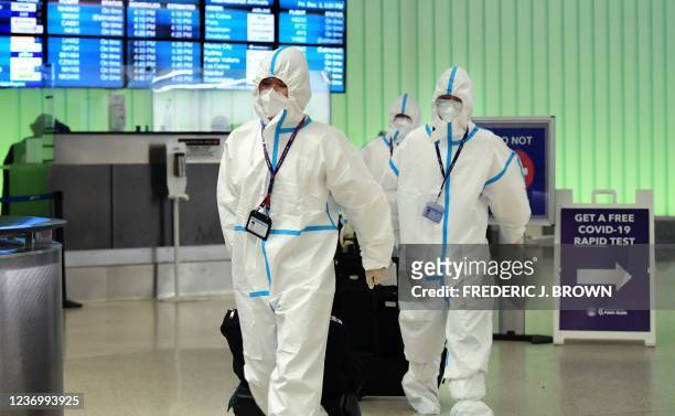 Flight crew from Air China arrive in hazmat suits in the international terminal at Los Angeles International Airport on December 3 as Los Angeles...