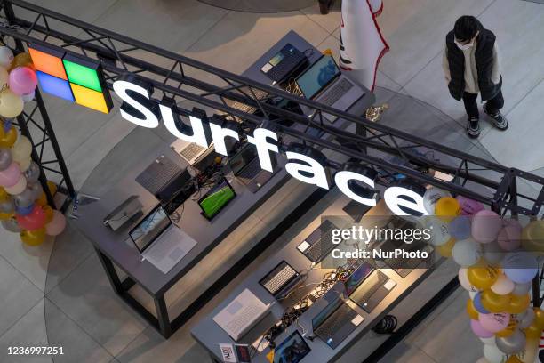 An Iranian boy looks at laptops while standing next to a logo of the Microsoft American company in an IT-City multi brand shop at the Paytakht...