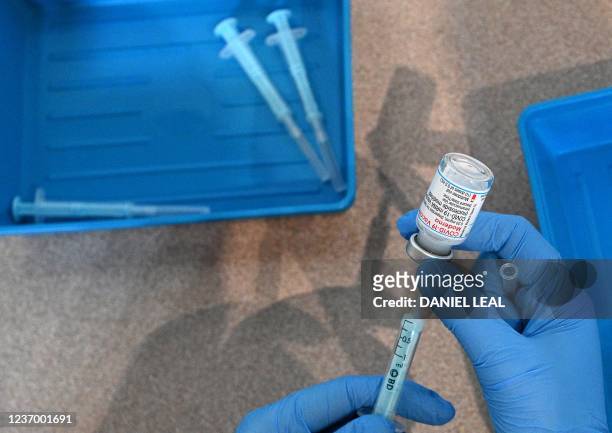 Clinician prepares doses of a Moderna Covid-19 booster vaccine at a temporary vaccination centre set up inside St John's Church in west London on...