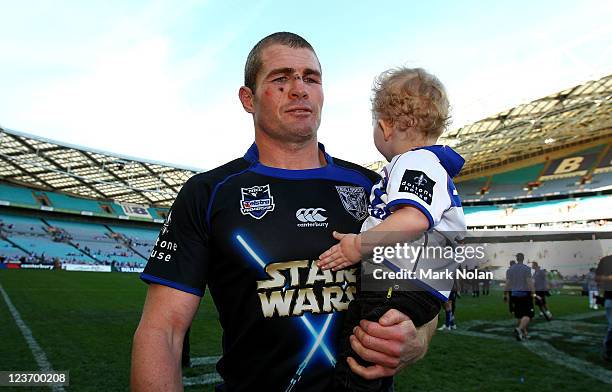 Andrew Ryan of the Bulldogs carries his son after the round 26 NRL match between the Canterbury-Bankstown Bulldogs and the Canberra Raiders at ANZ...