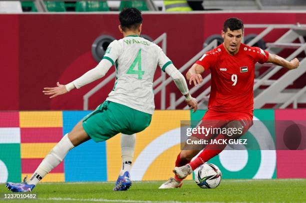Saudi Arabia's defender Waleed al-Ahmed tries to cut off Palestine's midfielder Tamer Seyam during the FIFA Arab Cup 2021 group C football match...