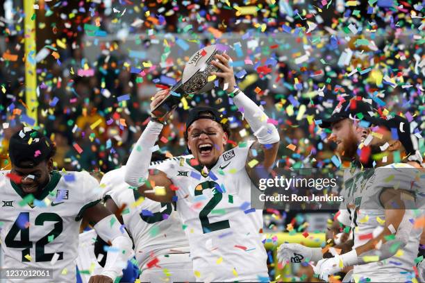 Terrel Bernard of the Baylor Bears holds the Big 12 Championship trophy and celebrates with teammates after Baylor defeated the Oklahoma State...