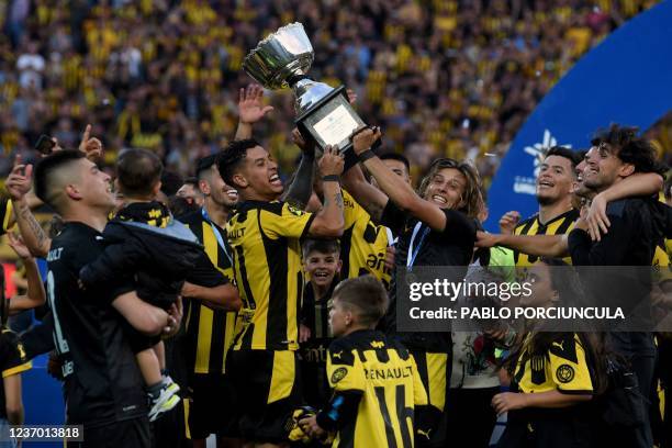 Peñarol's Agustin Canobbio and Jesus Trindade raise the trophy after winning the Uruguayan Clausura tournament at the Campeon del Siglo stadium in...