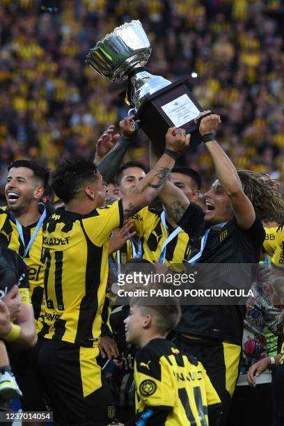 Peñarol's Agustin Canobbio and Jesus Trindade raise the trophy after winning the Uruguayan Clausura tournament at the Campeon del Siglo stadium in...