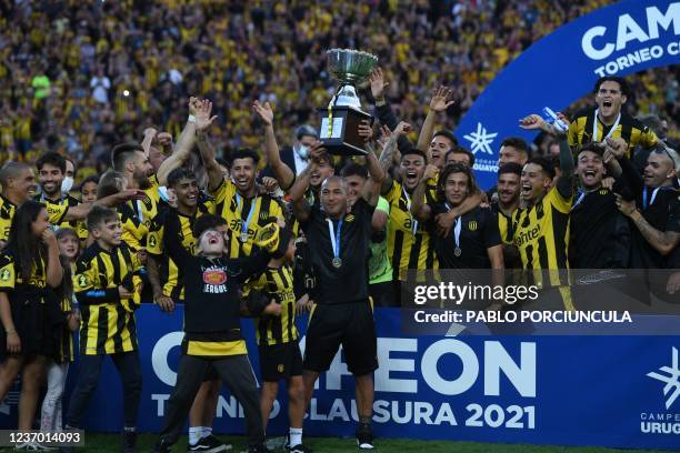 Peñarol's Walter Gargano raises the trophy after winning the Uruguayan Clausura tournament at the Campeon del Siglo stadium in Bañados de Carrasco,...