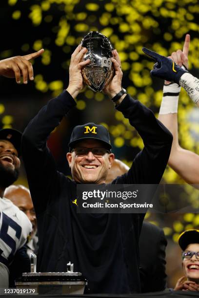 Michigan Wolverines Head Coach Jim Harbaugh raises the Big Ten Championship trophy after Michigan won the the Big 10 Conference Championship game...