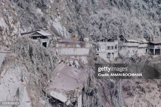 Ash covers houses and trees on the slopes of Mount Semeru in Lumajang on December 5 the day after a volcanic eruption on the mountain that killed at...
