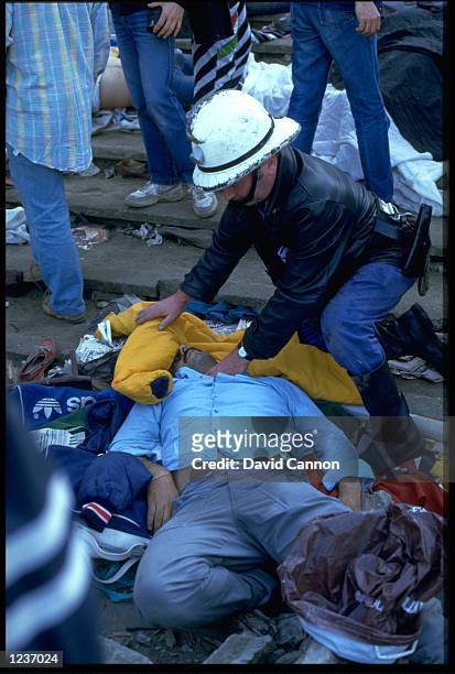 A RESCUER CHECKS FOR SIGNS OF LIFE FROM AN INJURED SUPPORTER WHO WAS CAUGHT UP IN A RIOT PRIOR TO THE EUROPEAN CUP FINAL IN THE HEYSEL STADIUM IN...