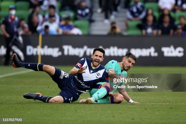 Stefan Nigro of Melbourne Victory and Bruno Fornaroli of Perth Glory fall during the round 3 A-League soccer match between Melbourne Victory and...