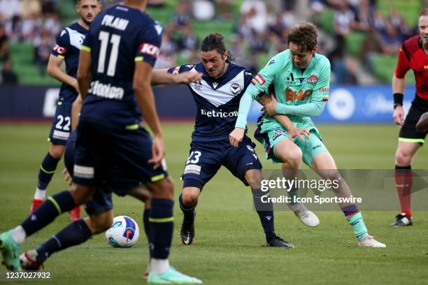 Daniel Stynes of Perth Glory tackles Marco Rojas of Melbourne Victory during the round 3 A-League soccer match between Melbourne Victory and Perth...
