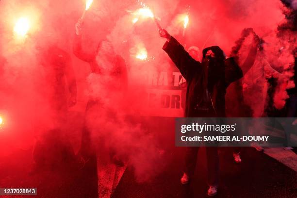 Demonstrators hold flares during a rally to protest against French far-right 2022 presidential candidate Eric Zemmour in Paris, on December 5, 2021...