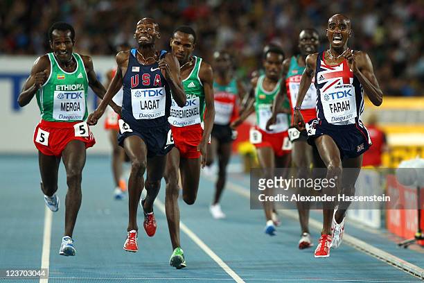 Mohamed Farah of Great Britain crosses the finish line ahead of Bernard Lagat of the USA to claim victory in the men's 5000 metres final during day...