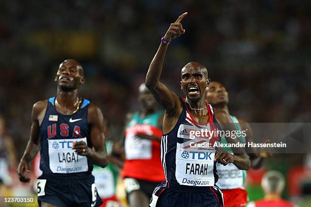 Mohamed Farah of Great Britain crosses the finish line ahead of Bernard Lagat of the USA to claim victory in the men's 5000 metres final during day...