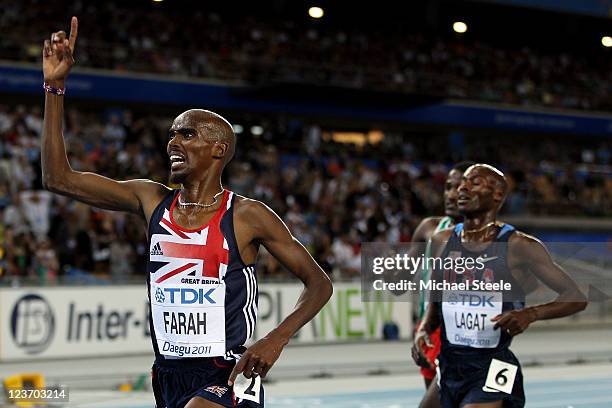 Mohamed Farah of Great Britain crosses the finish line ahead of Bernard Lagat of the USA and Imane Merga of Ethiopia to claim victory in the men's...