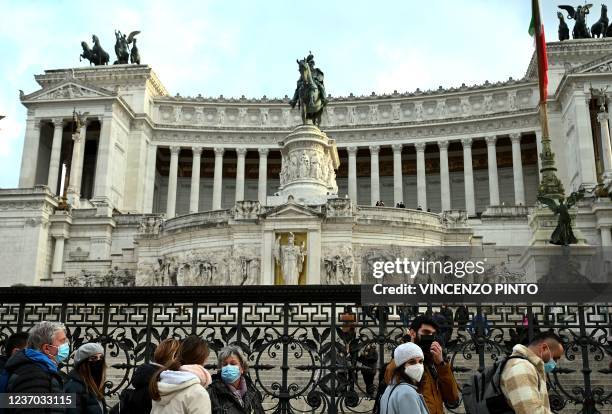 Visitors wearing face masks line up at the entrance to the Altare della Patria monument in Piazza Venezia on December 05, 2021 in Rome, as the city...