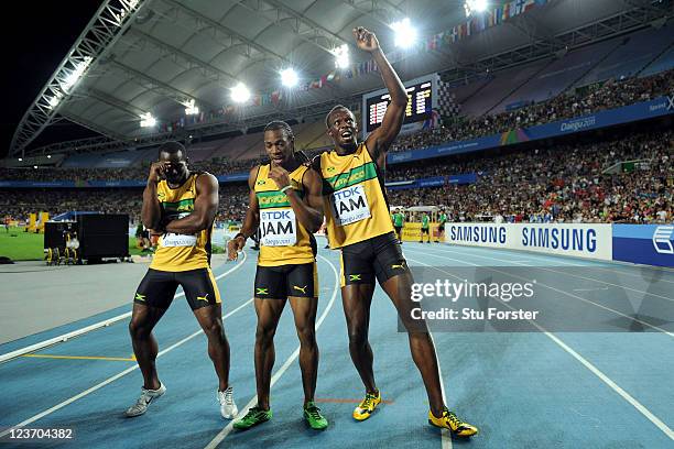 Nesta Carter, Yohan Blake and Usain Bolt of Jamaica celebrate victory and a new world record in the men's 4x100 metres relay final during day nine of...