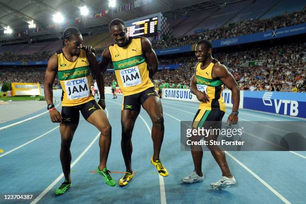 Yohan Blake, Usain Bolt and Nesta Carter of Jamaica celebrate victory and a new world record in the men's 4x100 metres relay final during day nine of...