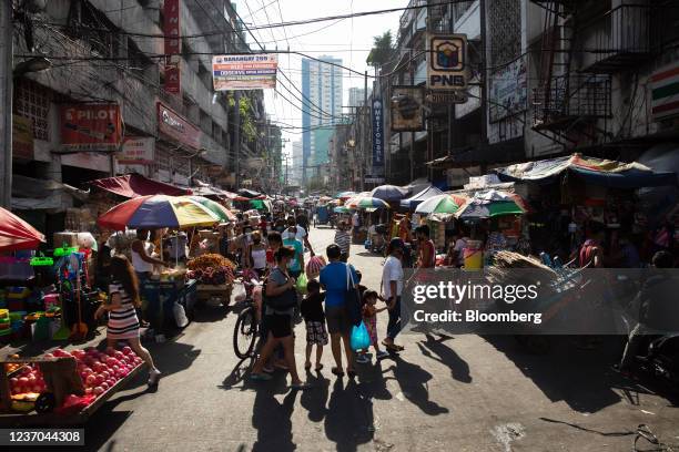 Shoppers walk past stalls at Divisoria Market in Manila, the Philippines, on Sunday, Dec. 5, 2021. The Philippines had loosened virus restrictions in...