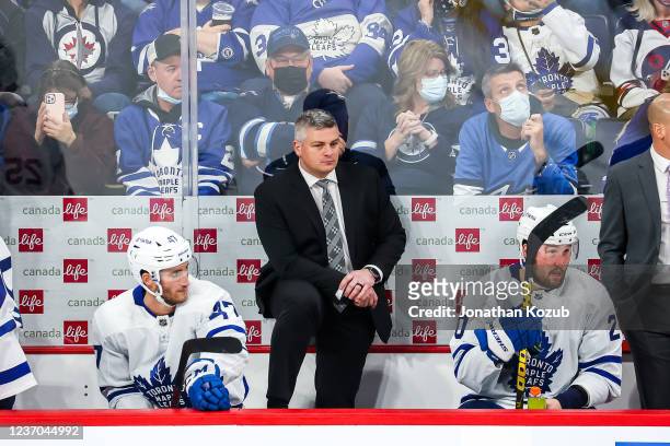 Head Coach Sheldon Keefe of the Toronto Maple Leafs looks on from the bench during a third period stoppage in play against the Winnipeg Jets at the...