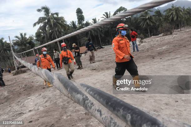 Search and rescue teams with residents evacuate the bodies of victims who died due volcanic material of Mount Semeru eruption in Sumberwuluh Village,...