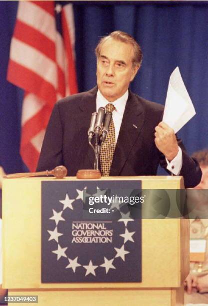 Presidential candidate Senator Bob Dole holds up a copy of a report while he addresses the National Governors' Association's 87th annual meeting 31...