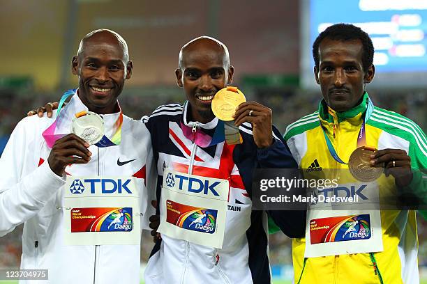 Mohamed Farah of Great Britain celebrates with his gold medal , Bernard Lagat of the USA the silver and Dejen Gebremeskel of Ethiopia the bronze,...