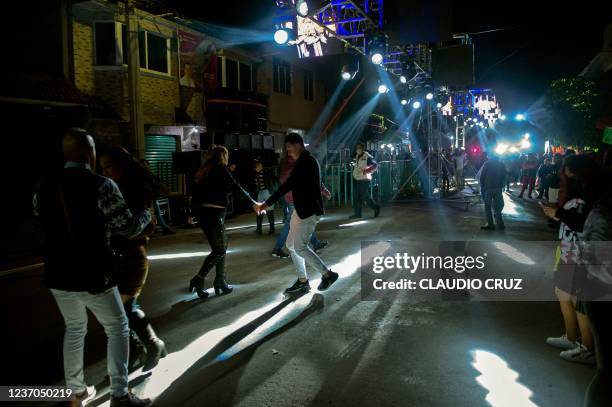 People dance in the street to the sound of Sonideros discs jockeys in Nezahualcoyotl, Mexico State, on December 4 following the return of street...