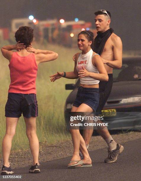 Residents are gathered along a street after they were evacuated by firemen from their house at Kurrajong in Sydney, late 25 December 2001. Bushfires...