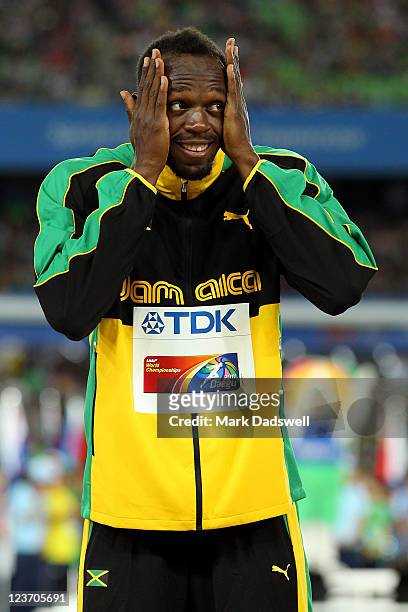 Usain Bolt of Jamaica prepares to receive his gold medal on the podium during the medal ceremony for the men's 200 metres final during day nine of...