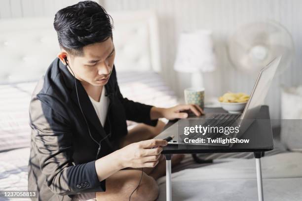 asiatische geschäftsmann videokonferenz mit business-verschleiß auf top und boxershorts auf dem bett tun arbeit von zu hause - usb stick stock-fotos und bilder