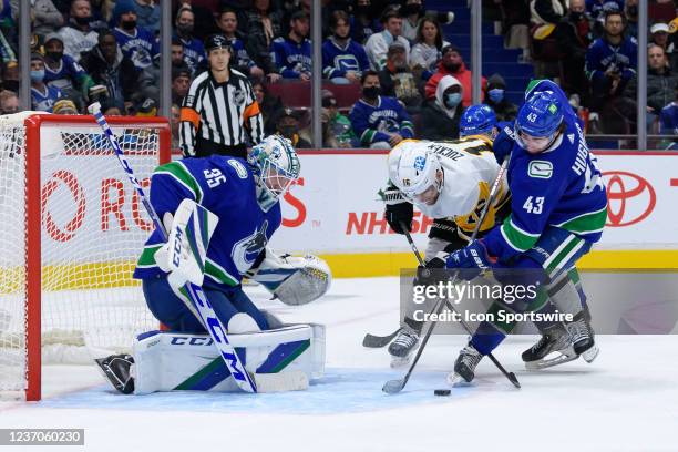 Vancouver Canucks goaltender Thatcher Demko and defenseman Quinn Hughes defend against Pittsburgh Penguins left wing Jason Zucker during their NHL...