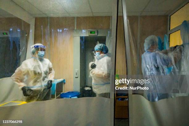 Doctors and nurses take off their protection equipment suits in a isolated safety area of the intensive cares units of the Kiev City Clinical...