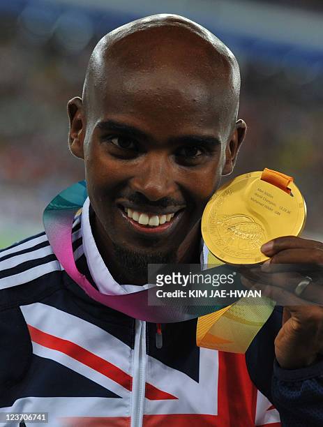 Gold medallist Britain's Mohammed Farah poses during the award ceremony for the men's 5,000 metres event at the International Association of...